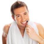 A man with a dental bridge brushing his teeth