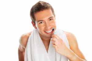 A man with a dental bridge brushing his teeth