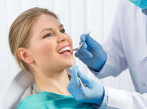 A dentist examining a patient's teeth to replace a metal crown with a porcelain crown